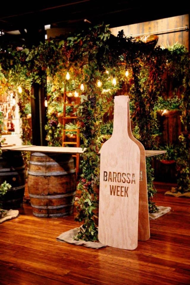 a wooden sign that says barbossa week next to some barrels with plants growing on them