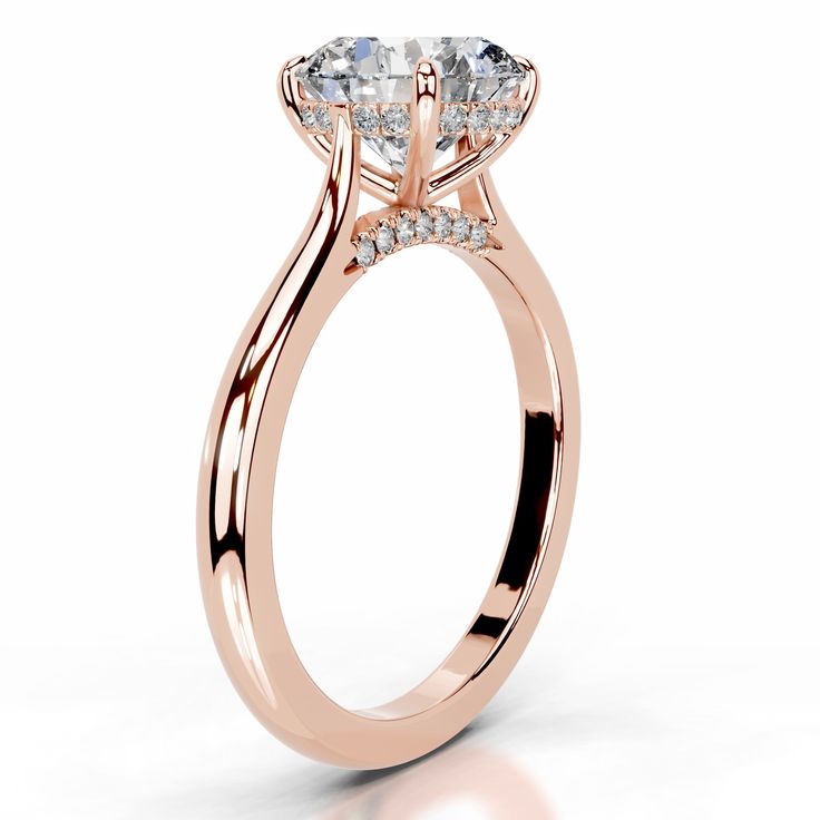 a rose gold engagement ring with an oval cut diamond in the center and side stones