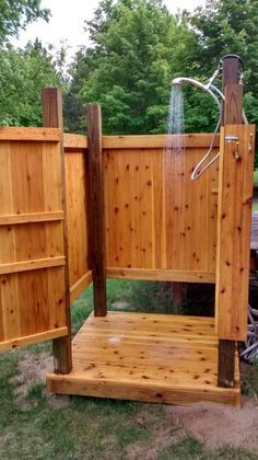 a wooden shower in the middle of a yard