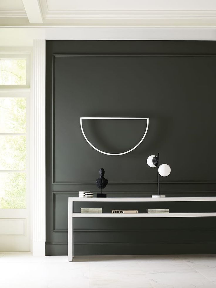 a modern living room with black walls and white trim on the wall, along with a console table