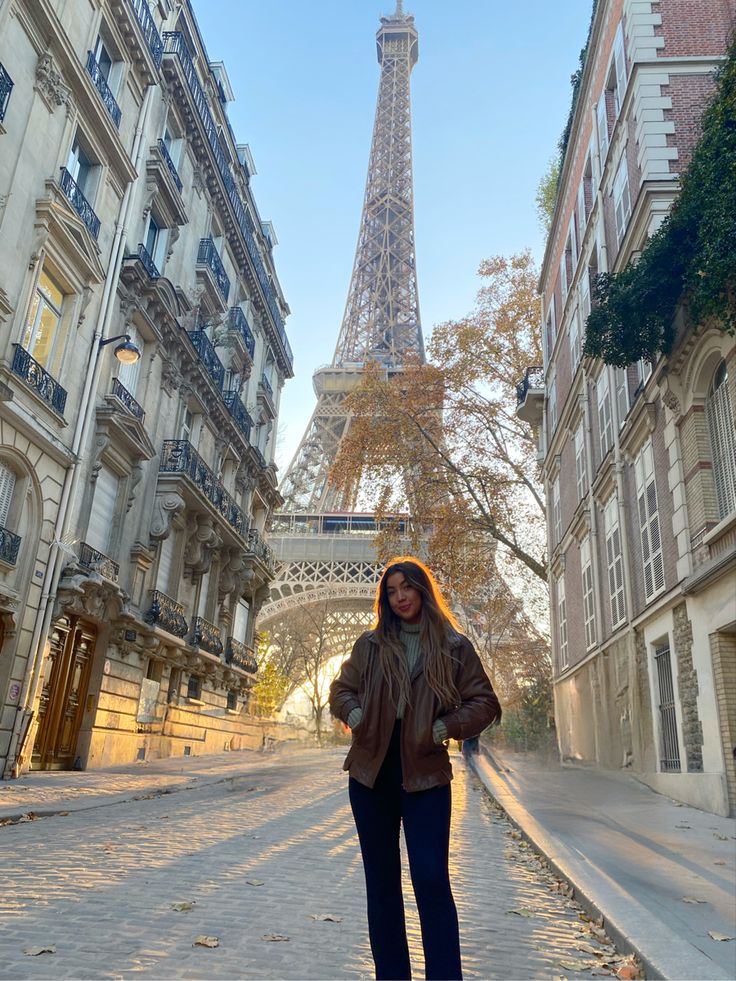 a woman standing in front of the eiffel tower