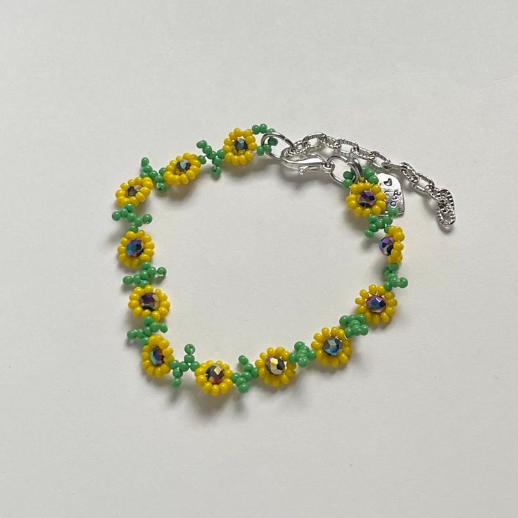 "Handmade Beaded Bracelet 🌻 I also have a matching necklace available ✿ Made with glass seed beads, glass crystal beads, and metal accents ✿ Green, yellow, and multicolored/oil-slick ✿ 6.75 - 7.25\" (slightly stretchy) plus 2\" of extension chain" Green Beaded Flower Crystal Bracelet, Yellow Czech Glass Bracelets With Round Beads, Yellow Beaded Chain Bracelet, Yellow Beaded Chain Bracelets, Adjustable Yellow Beaded Bracelets With Beaded Chain, Adjustable Yellow Beaded Crystal Bracelet, Adjustable Yellow Beaded Bracelet, Adjustable Yellow Beaded Chain Bracelets, Adjustable Beaded Yellow Crystal Bracelet