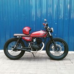 a red motorcycle parked in front of a blue wall