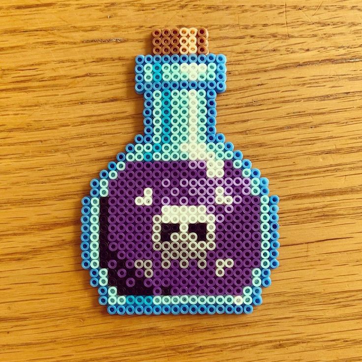 a bottle shaped like a pixel art piece on a wooden table