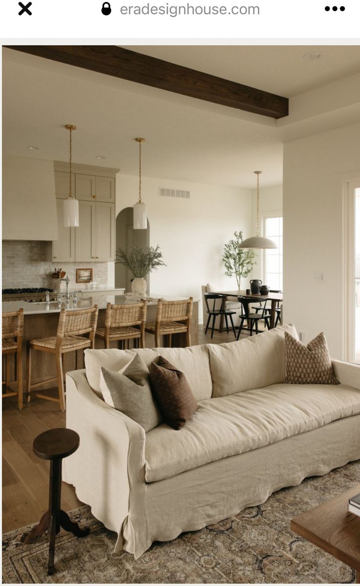 a living room filled with furniture next to a kitchen