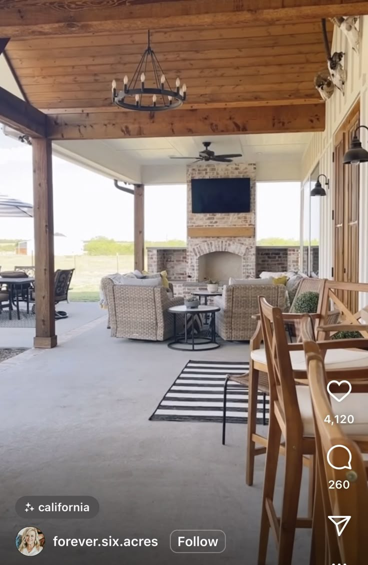 an outdoor living room and dining area with wood ceilinging, patio furniture and fireplace