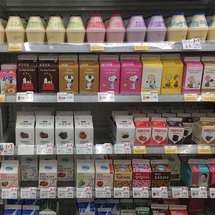 an assortment of milk and juices on display in a store