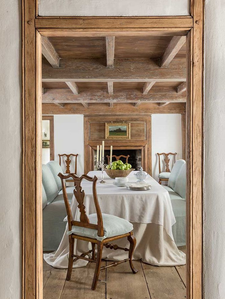 a dining room with a table and chairs in front of a mirror that is reflecting it's interior