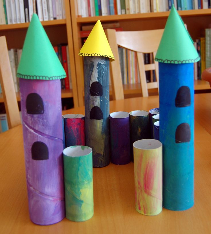 some very cute looking colored paper rolls on a table in front of bookshelves