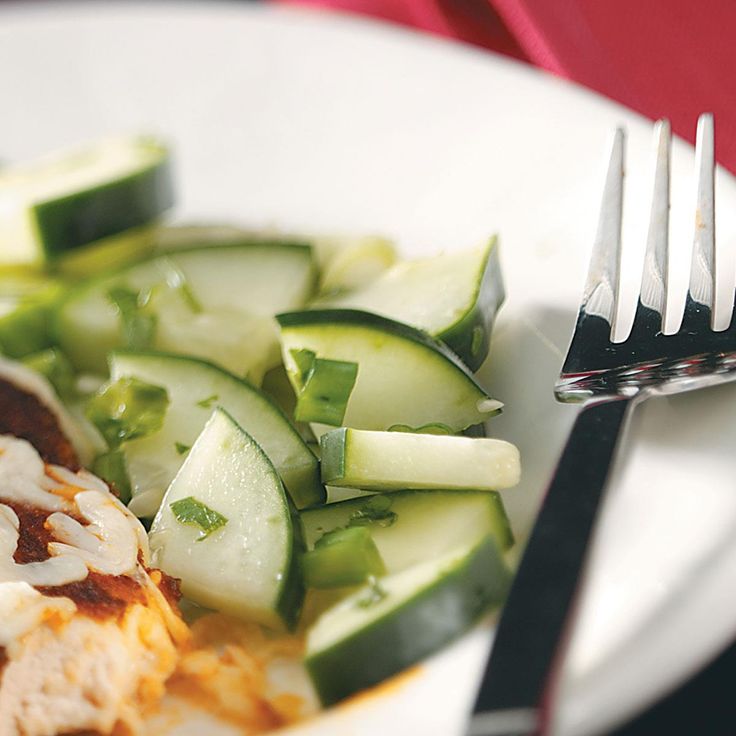 a close up of a plate of food with cucumbers and meat on it