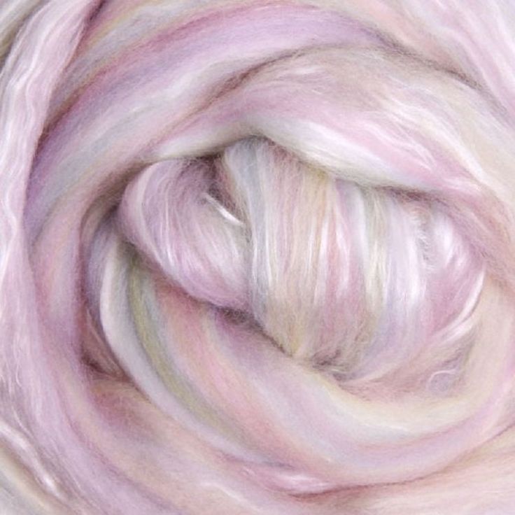 a close up view of a pink and white yarn ball with the wool spinning in it's center