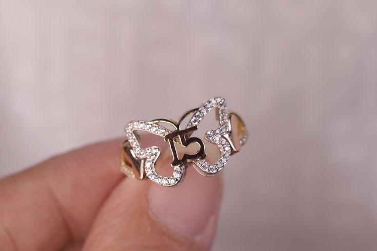 a person holding a ring with the number 55 on it's side in their hand