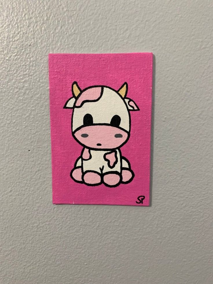 a pink square with a cartoon cow painted on it's front and bottom corner