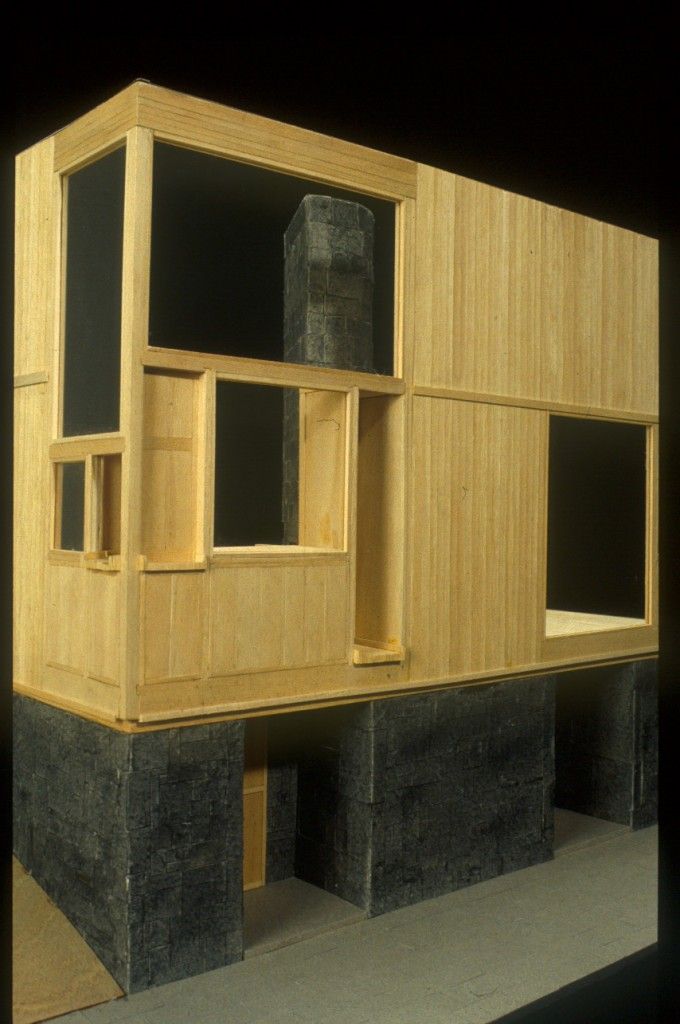 a model of a house made out of wood and concrete blocks, with no doors or windows