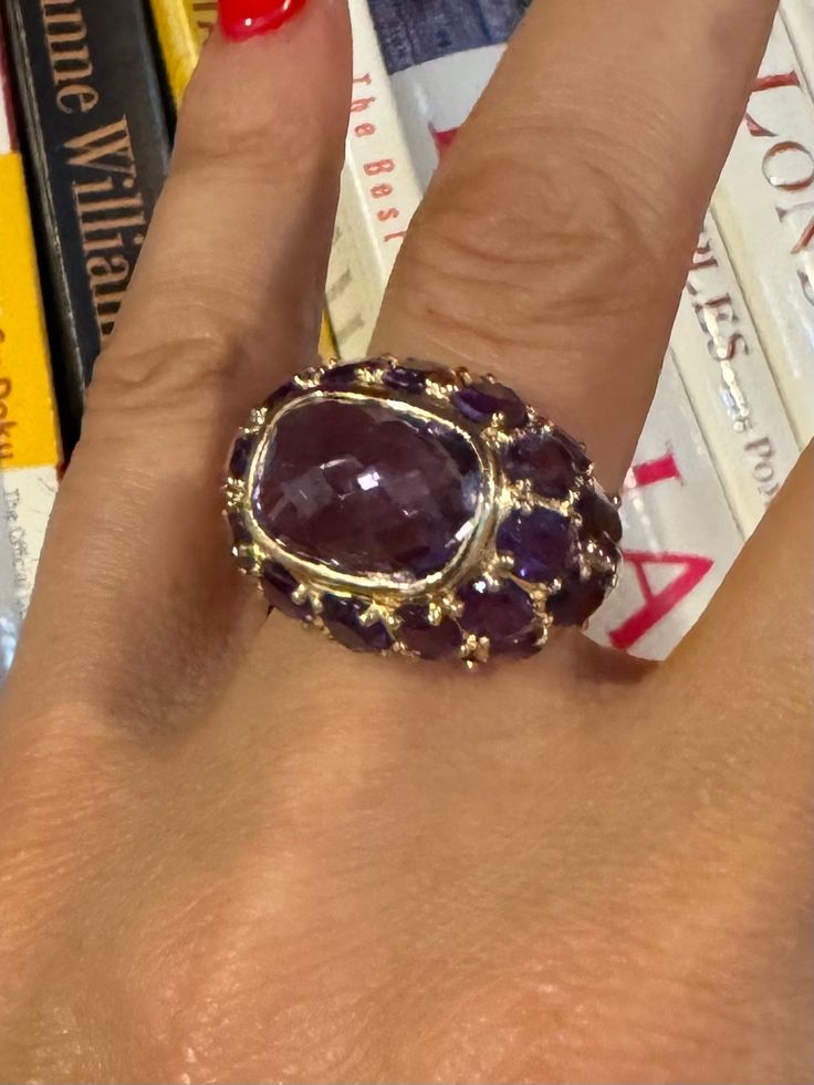 Thank you for viewing Wrenn Estate  Stunning 14 Karat Amethyst Bombe Vintage Ring Size 8 8.68 grams 14k Yellow Gold   Approximately 15 carat center amethyst 14x11mm Hallmarked "14k" 18 mm wide at widest top 2.5 mm wide at narrowest back  Exquisite 14 karat amethyst Bombe vintage ring. Featuring a bold and vibrant fantasy cut amethyst centerpiece and 20 oval amethysts, this ring captures the essence of vintage glamour. The rich purple hue of the amethyst is beautifully complemented by the warm gl Luxury Faceted Amethyst Ring For Formal Occasions, Luxury Faceted Amethyst Ring For Formal Events, Luxury Purple Amethyst Cabochon Ring, Luxury Purple Cabochon Amethyst Ring, Luxury Amethyst Cabochon Ring, Luxury Purple Multi-stone Sapphire Ring, Luxury Faceted Gemstones For Anniversary, Purple Ruby Ring For Formal Occasions, Luxury Purple Oval Gemstones