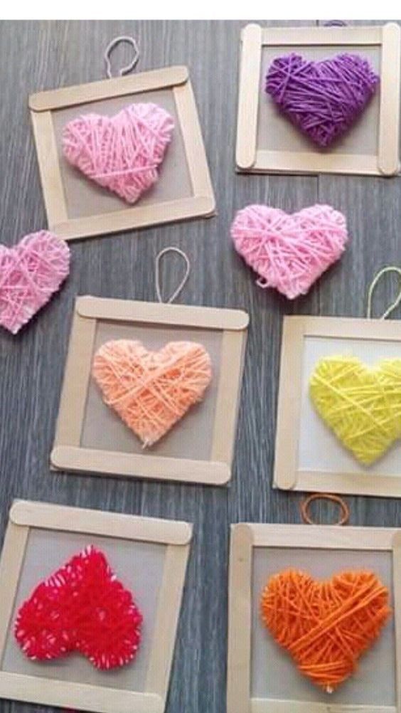 there are many different types of yarn hearts in the picture frame and on the table