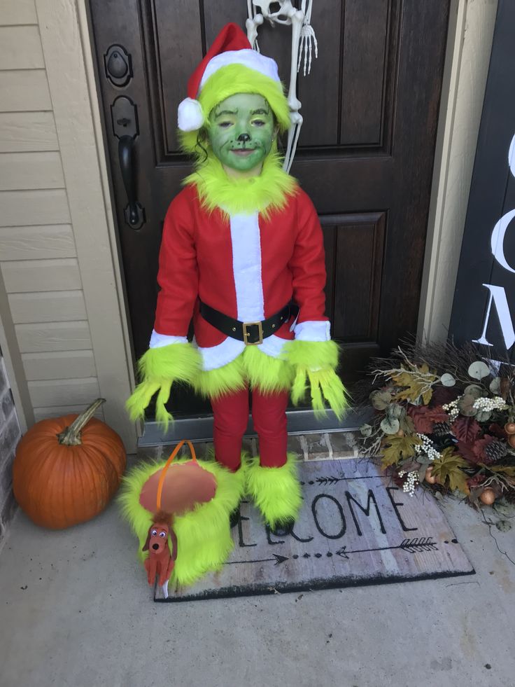 the grinch costume is on display in front of a door with pumpkins and other decorations