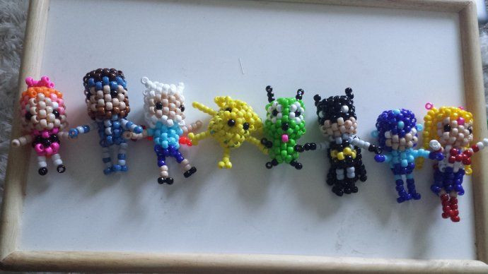 the beaded cartoon characters are arranged in a wooden frame