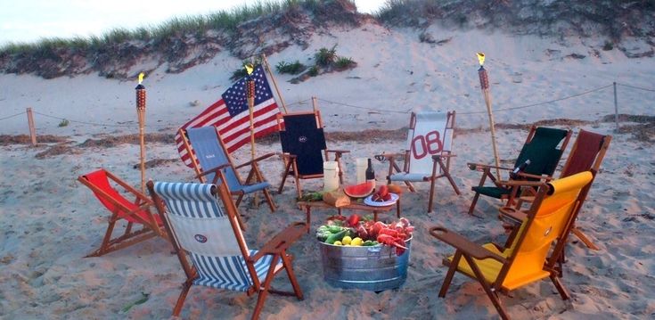 a bunch of chairs that are sitting in the sand