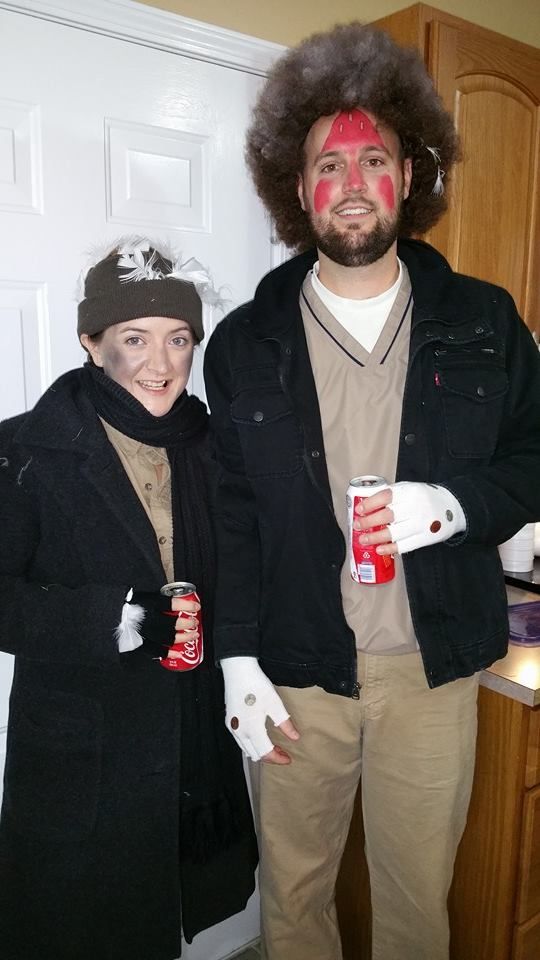 a man and woman standing next to each other in front of a door with red paint on their face