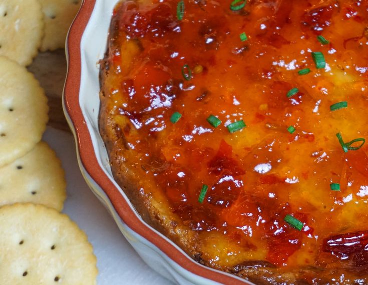 a baked dish in a bowl with crackers around it