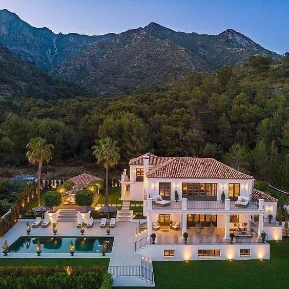 this is an aerial view of the house at night with its pool and mountains in the background