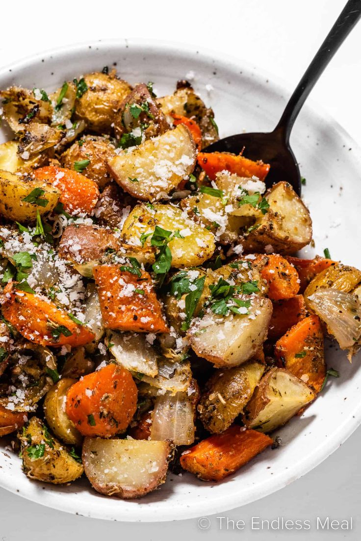 a white bowl filled with roasted vegetables and parmesan cheese