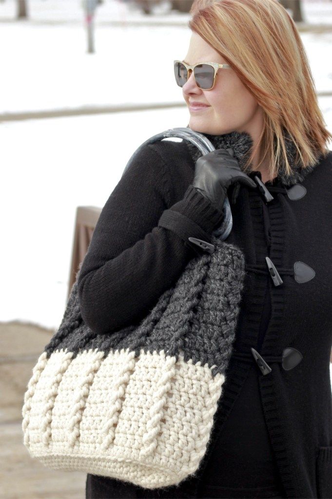 a woman carrying a crocheted purse in the snow with her hand on her shoulder