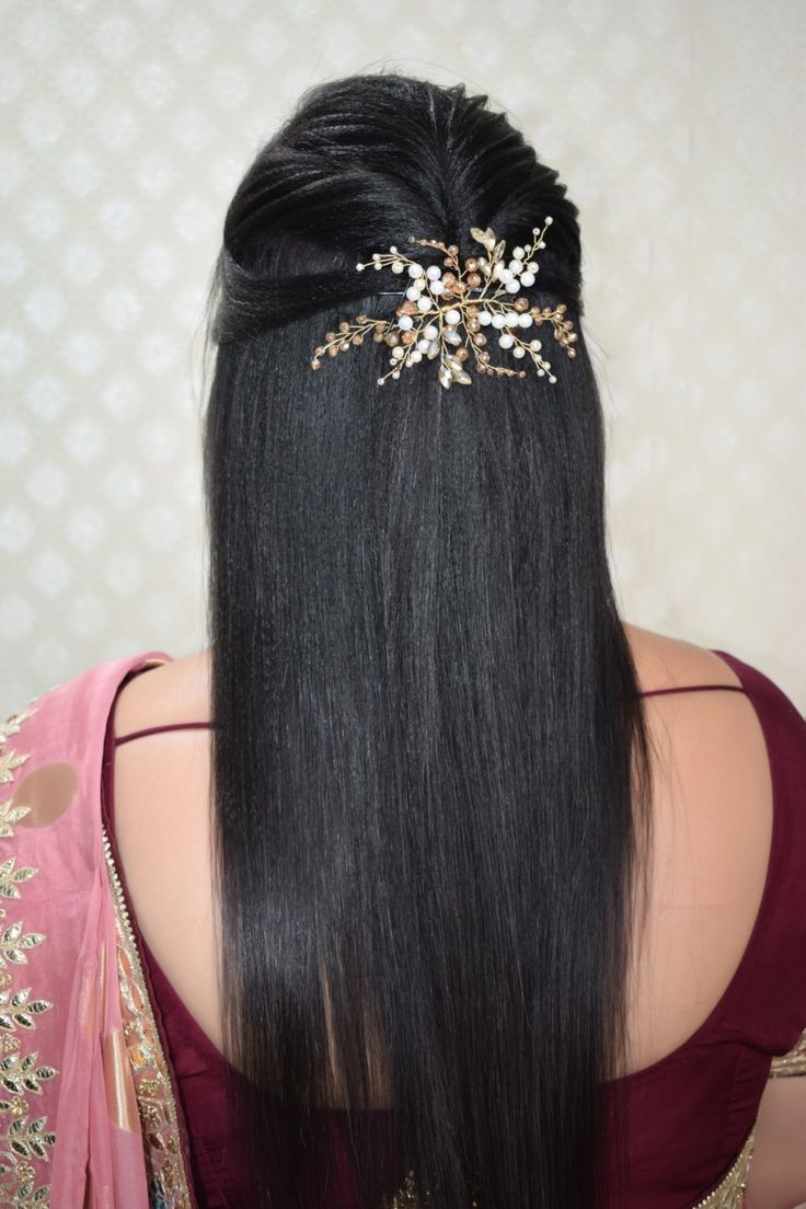 the back of a woman's head with long black hair wearing a gold and crystal tiara