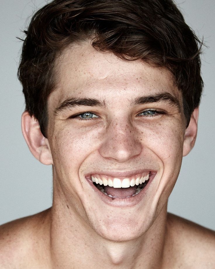 a man with freckled hair smiling at the camera