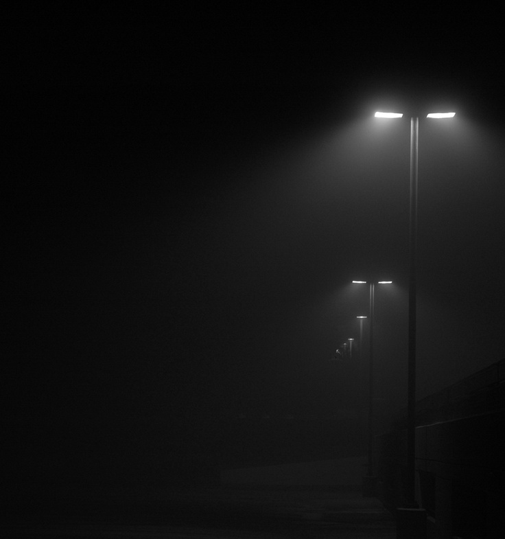 two street lights in the dark on a foggy night