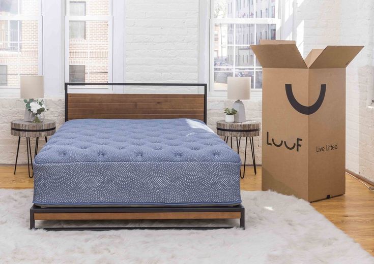 a blue mattress sitting on top of a bed in a bedroom next to a cardboard box