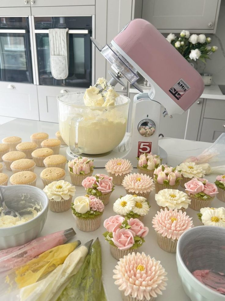 cupcakes being made in a kitchen with flowers and icing on the counter