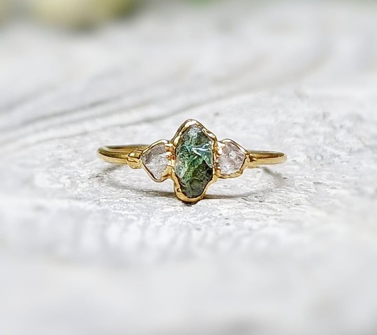 CUT-OFF DATE TO RECEIVE YOUR ORDER BY CHRISTMAS: Sunday December 10th, 2023 All orders received AFTER December 10th will be created and shipped after the Christmas Holidays. For you free-spirited Nature Lovers - what's not to Love about this dainty Green Sapphire and diamond engagement ring? Our lovely crystal ring features a natural raw Green Sapphire nestled between 2 sparkly clear Herkimer diamonds and uniquely handcrafted by electroforming on a Sterling Silver band. Whether to celebrate a bl Recycled Engagement Ring, Antique Green Engagement Rings, Dainty Non Traditional Engagement Rings, Raw Rock Engagement Ring, Unique Earthy Engagement Rings, Raw Cut Rings, Sapphic Engagement Ring, Unique Stones For Engagement Rings, Homemade Engagement Ring