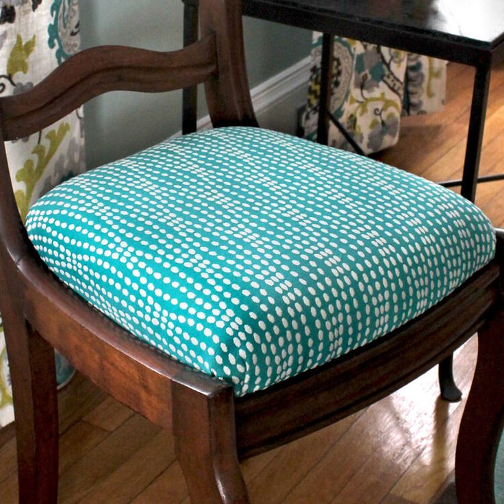 a wooden chair with a blue and white checkered seat cover on it's back