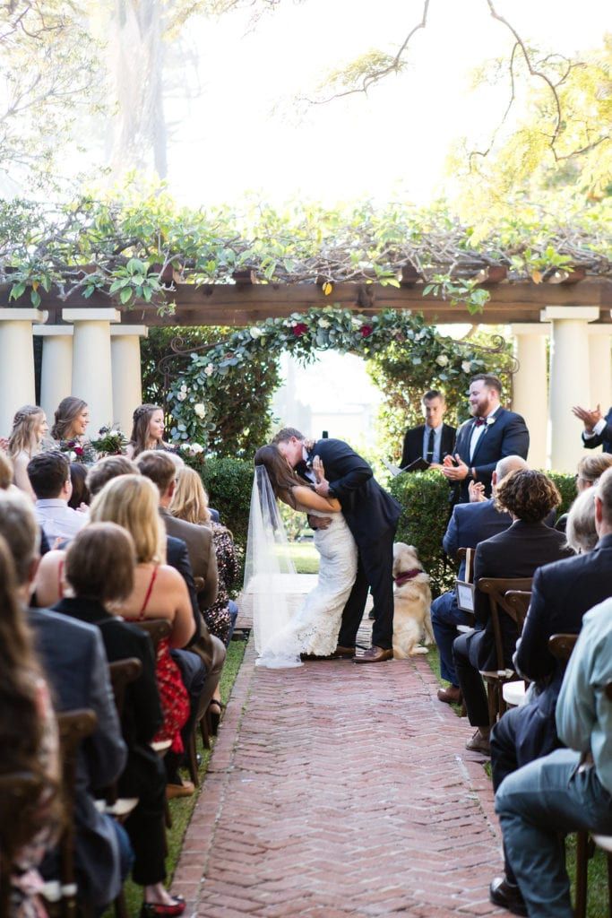 a bride and groom kissing in front of an outdoor ceremony