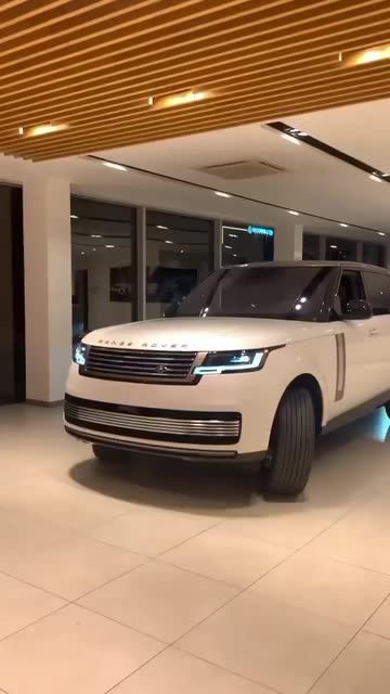 a white range rover is parked in a showroom