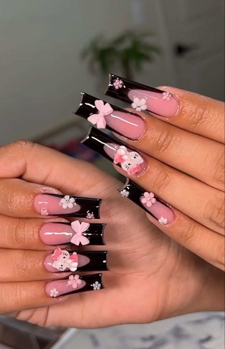 a woman with pink and black nail polish holding up her nails