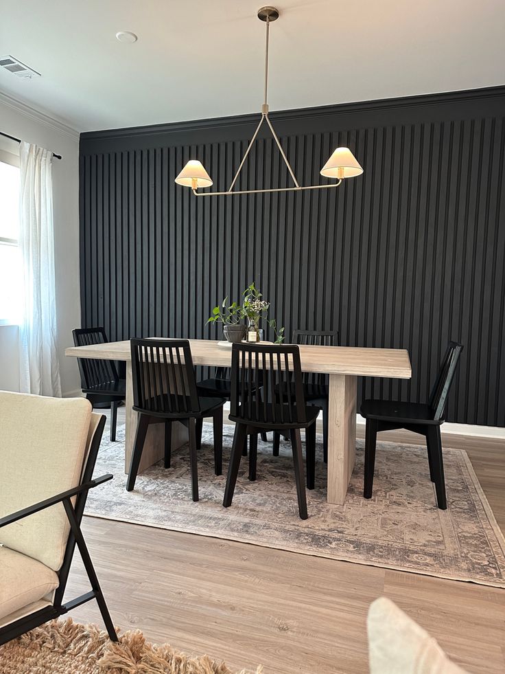 a dining room table with chairs and a rug