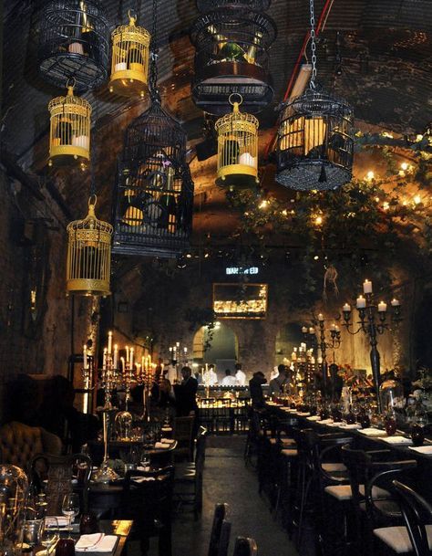 a restaurant with several birdcages hanging from the ceiling