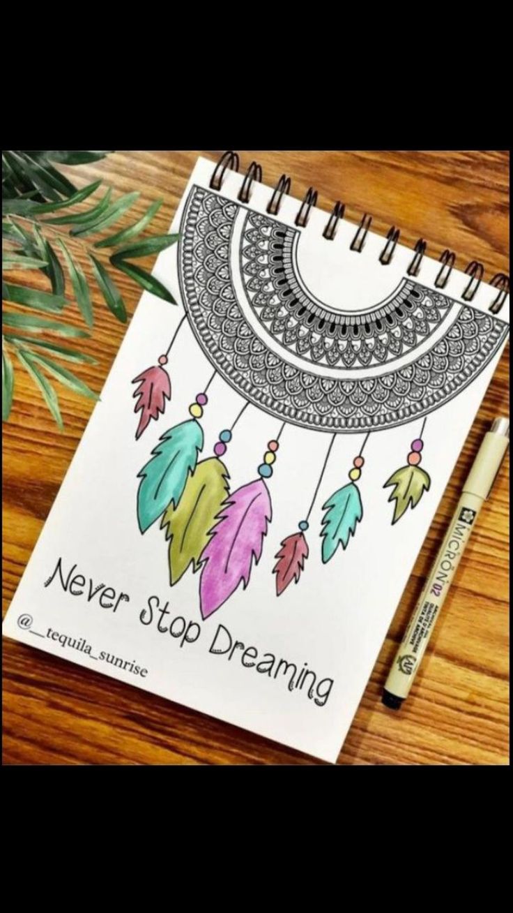 a notebook with an image of a dream catcher and the words never stop dreaming on it