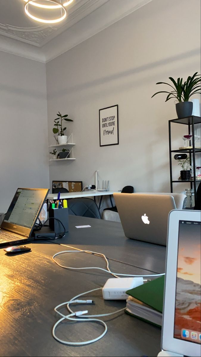 an open laptop computer sitting on top of a wooden table next to a macbook