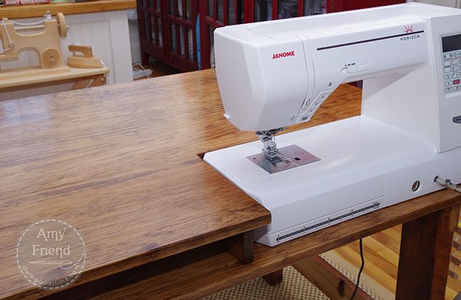 a white sewing machine sitting on top of a wooden table