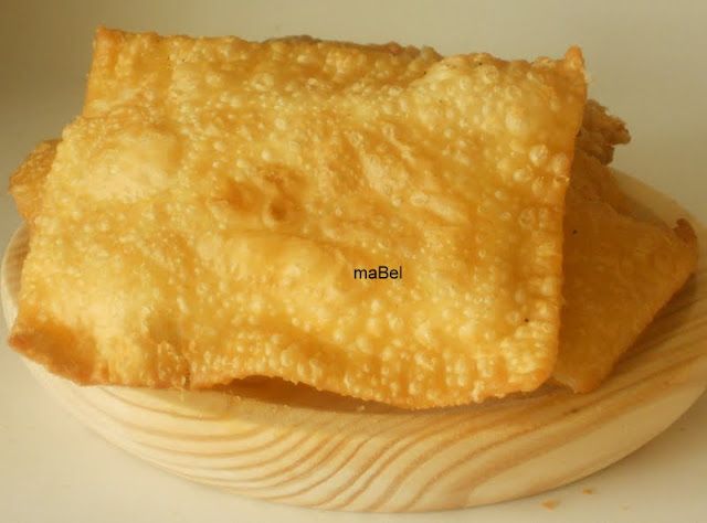 two square pieces of food sitting on top of a wooden plate