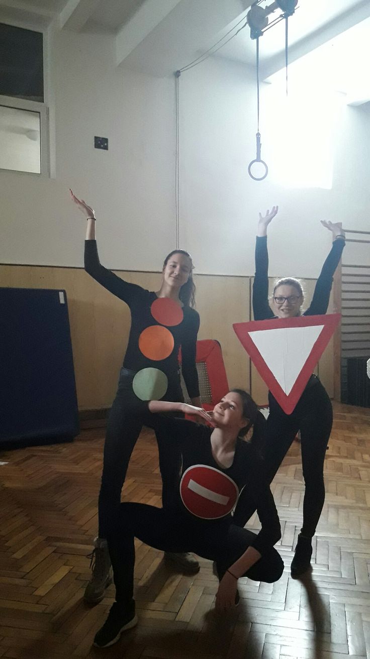 three people are posing with their arms in the air