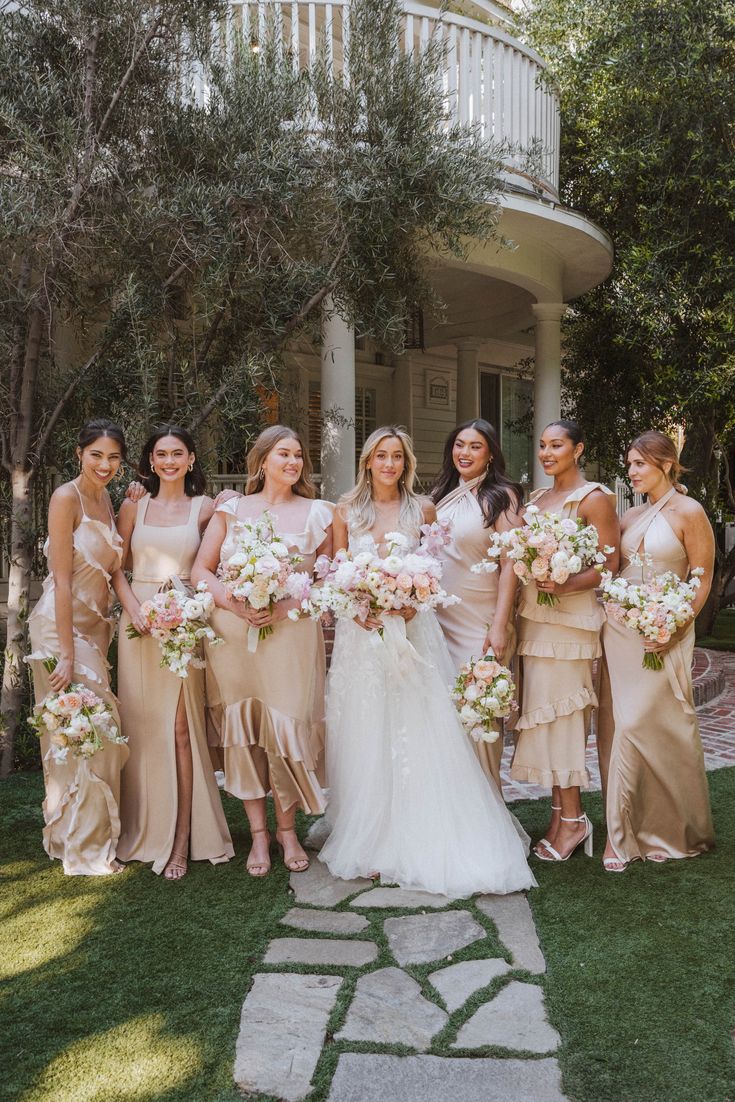 a group of women standing next to each other in front of a building