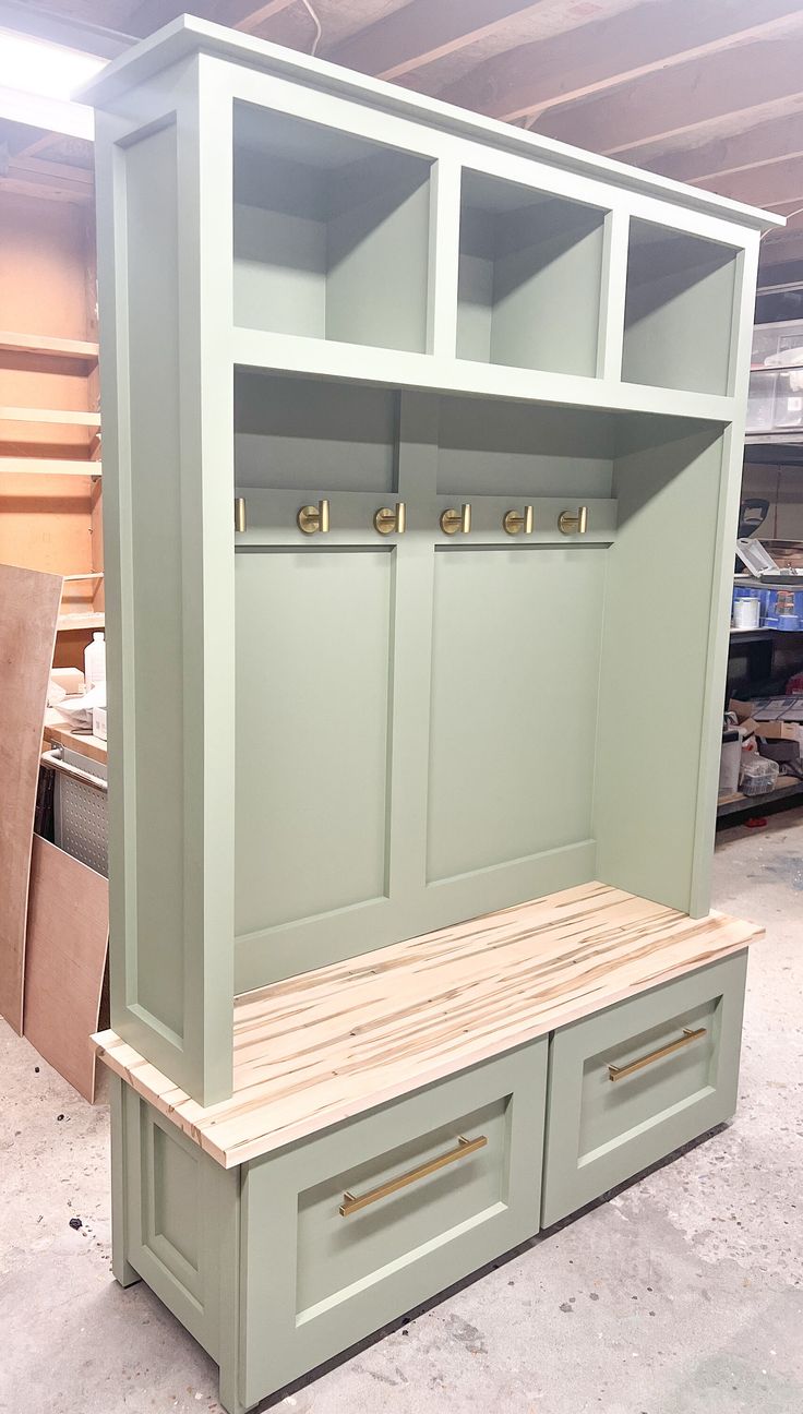 a large green cabinet with drawers and benches