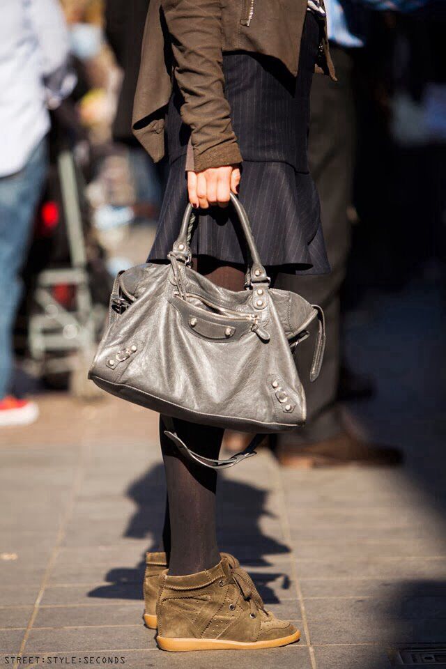 a woman carrying a gray purse on the street