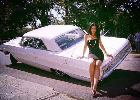 a woman sitting on the hood of a white car