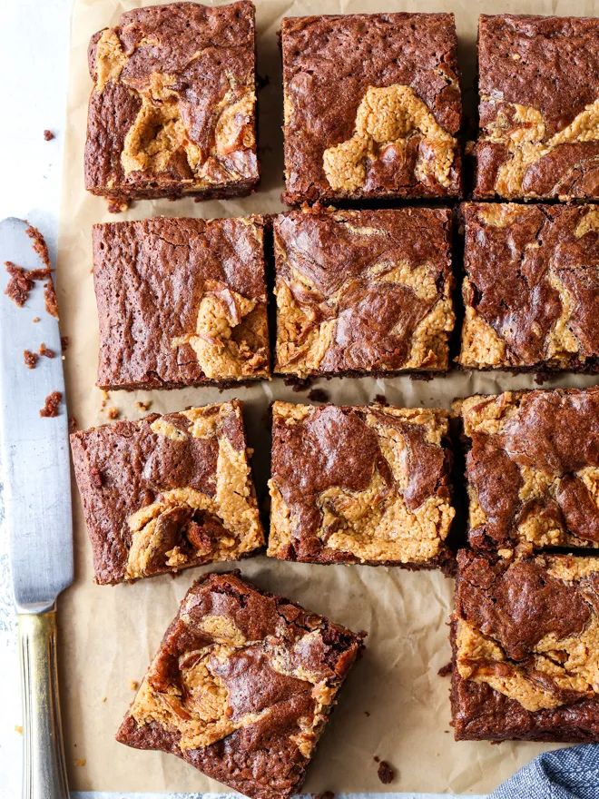 chocolate brownies cut into squares and sitting on a cutting board with a knife next to them